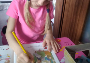 Dziewczynka wykonuje ćwiczenia w książce